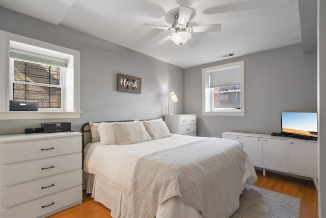bedroom featuring multiple windows, light wood-type flooring, and a ceiling fan