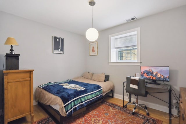 bedroom featuring wood finished floors and baseboards