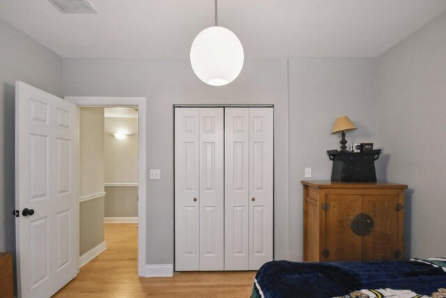 bedroom featuring light wood-style floors, a closet, and baseboards
