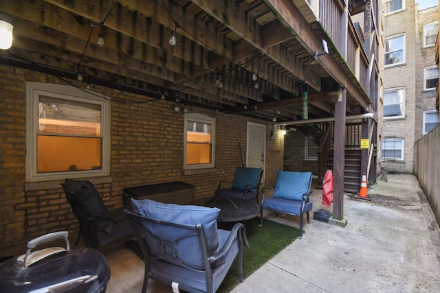 view of patio featuring stairs and fence