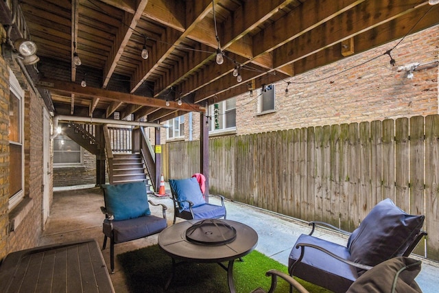 view of patio / terrace with stairs, an outdoor fire pit, and fence
