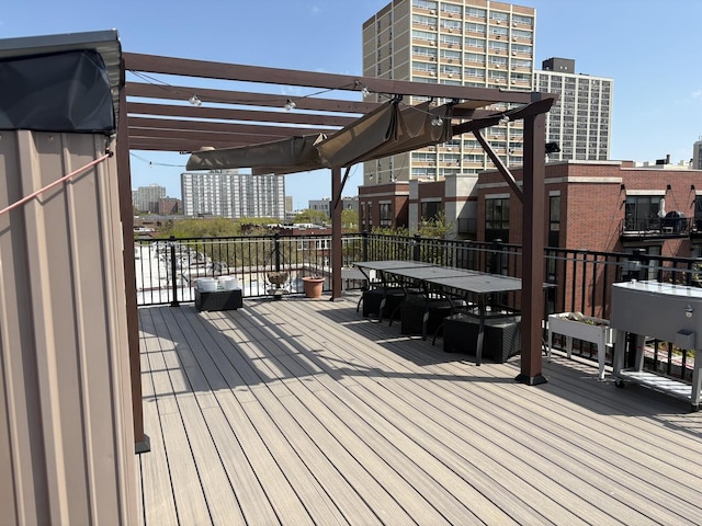 deck featuring a city view, a pergola, and outdoor dining area