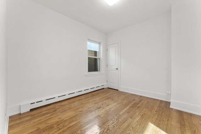 7732 W Sunset Dr, Elmwood Park, IL 60707 - unfurnished room with baseboards, a baseboard radiator, and light wood-type flooring