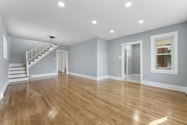 7732 W Sunset Dr, Elmwood Park, IL 60707 - unfurnished living room with baseboards, stairway, and light wood-style flooring