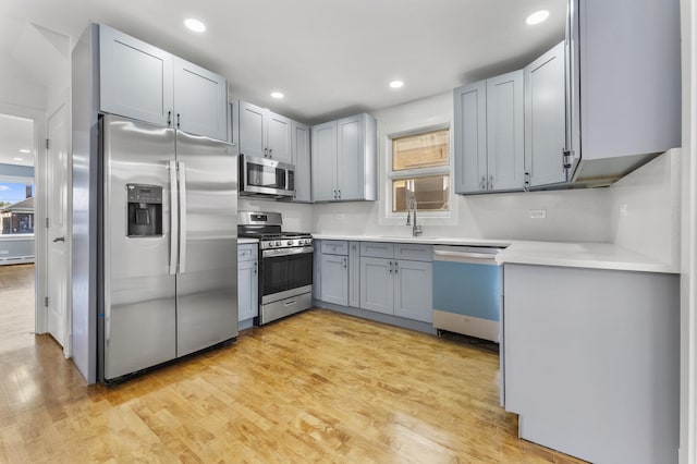 7732 W Sunset Dr, Elmwood Park, IL 60707 - kitchen featuring a sink, stainless steel appliances, recessed lighting, light wood-style flooring, and light countertops