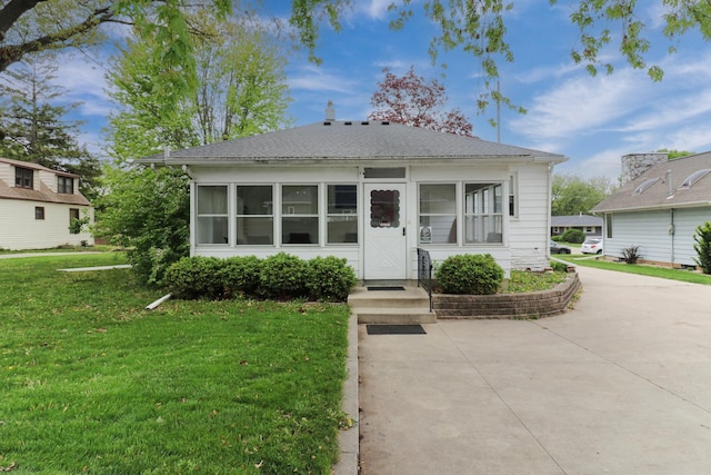 704 S Cottage Ave, Normal, IL 61761 - view of front of property featuring a front yard, a shingled roof, and a sunroom