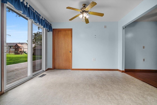 unfurnished room with ceiling fan and baseboards