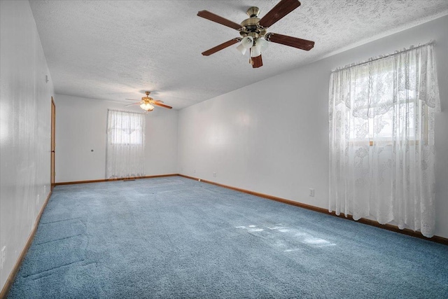spare room featuring ceiling fan, a textured ceiling, carpet, and baseboards