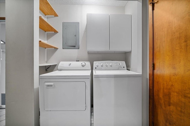 clothes washing area with separate washer and dryer, cabinet space, electric panel, and a textured ceiling
