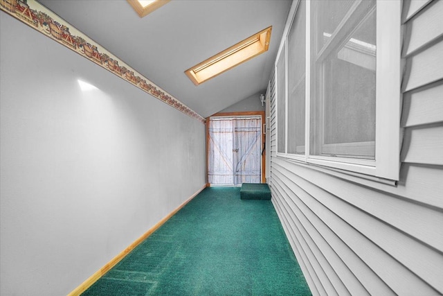 unfurnished room with vaulted ceiling, a skylight, and carpet floors