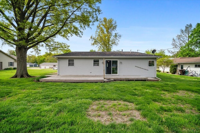 rear view of property with a wooden deck and a lawn