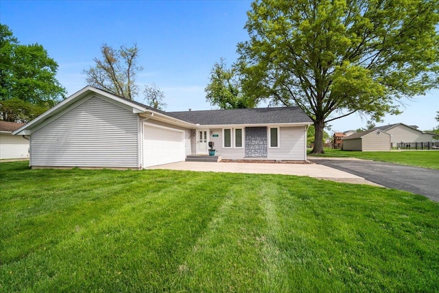 ranch-style home featuring driveway, a garage, and a front lawn