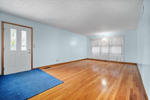 entrance foyer featuring wood finished floors, a textured ceiling, and baseboards