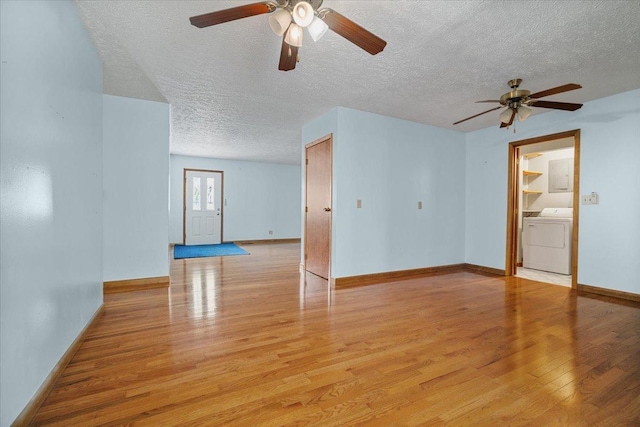 unfurnished living room featuring ceiling fan, light wood-style floors, a textured ceiling, washing machine and dryer, and baseboards