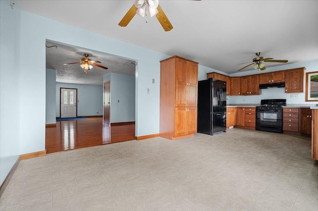 kitchen with black appliances, ceiling fan, and under cabinet range hood
