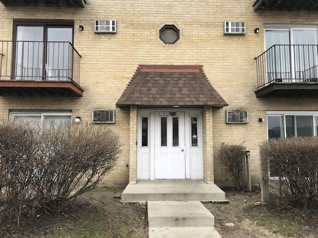 4214 Bonhill Dr Unit 3E, Arlington Heights, IL 60004 - doorway to property with a balcony, brick siding, and roof with shingles