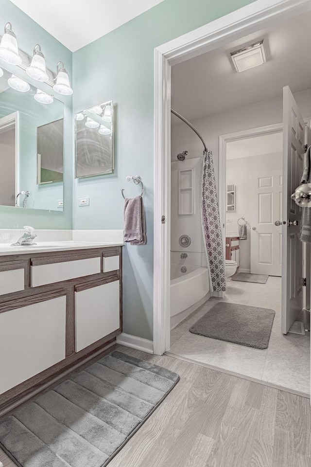 full bath featuring vanity, shower / bath combo, and toilet