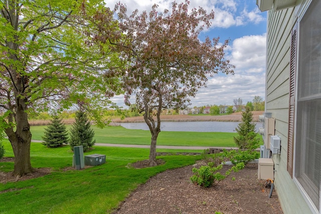 view of green lawn with a water view and view of golf course