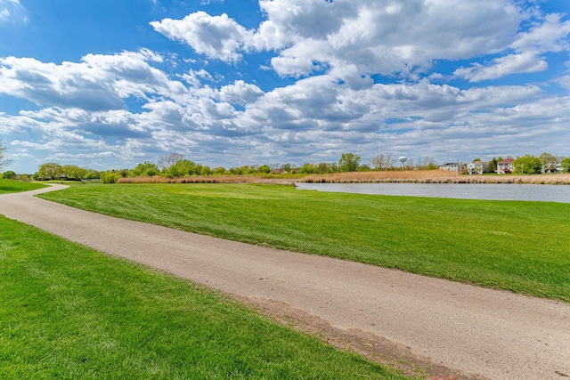 surrounding community featuring a water view and a yard