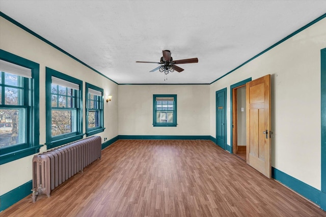 305 W Oregon St, Urbana, IL 61801 - unfurnished room with a ceiling fan, wood finished floors, baseboards, and radiator heating unit