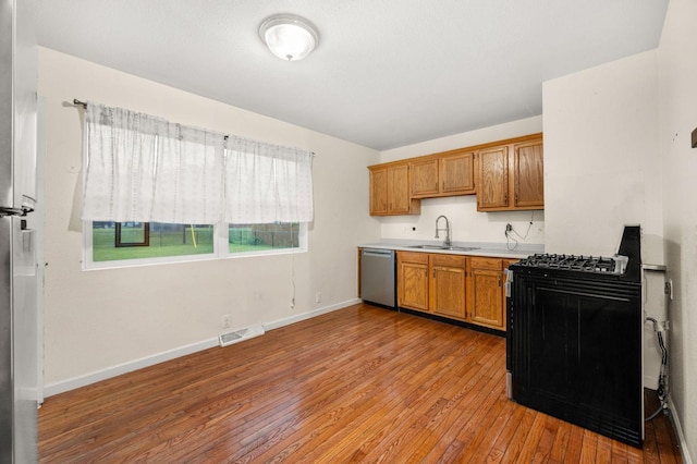 927 Lakeview Dr, Rochelle, IL 61068 - kitchen featuring dishwasher, a sink, light wood-type flooring, gas range, and light countertops