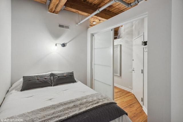225 W Huron St Unit 507, Chicago, IL 60654 - bedroom with beamed ceiling, light wood-style flooring, visible vents, and wooden ceiling