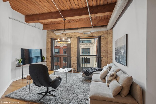 225 W Huron St Unit 507, Chicago, IL 60654 - living room featuring beamed ceiling, brick wall, wooden ceiling, and wood finished floors