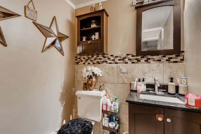 bathroom with toilet, vanity, crown molding, and tasteful backsplash