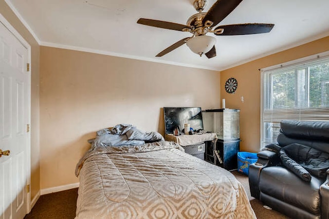 carpeted bedroom with baseboards, crown molding, and a ceiling fan