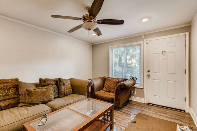 living area with ornamental molding, recessed lighting, light wood-style flooring, a ceiling fan, and baseboards