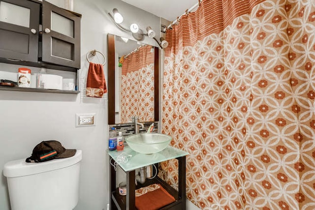 full bath featuring toilet, vanity, and a shower with shower curtain