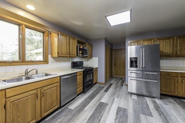 3128 Frans Ct, Winthrop Harbor, IL 60096 - kitchen with stainless steel appliances, a sink, light wood finished floors, backsplash, and light countertops