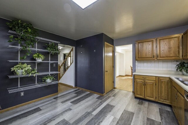 3128 Frans Ct, Winthrop Harbor, IL 60096 - kitchen with light wood finished floors, tasteful backsplash, light countertops, brown cabinets, and baseboards