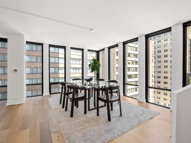 dining space with floor to ceiling windows and light wood-type flooring