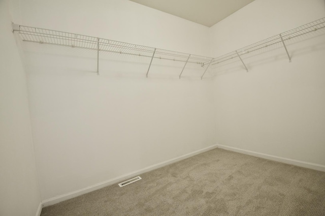 walk in closet with light carpet and visible vents