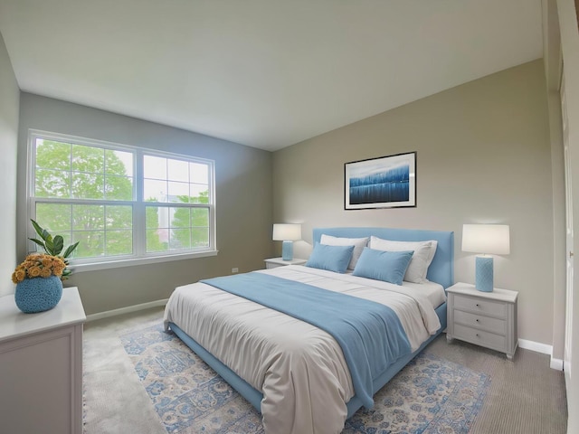 bedroom with baseboards and light colored carpet