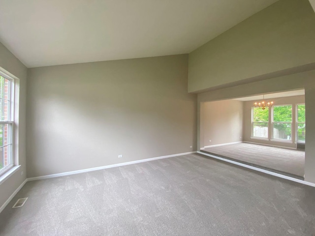 carpeted empty room with a wealth of natural light, visible vents, baseboards, and a notable chandelier