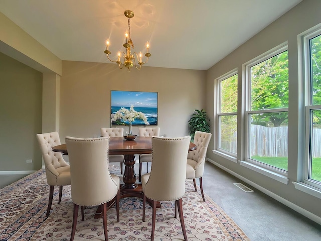 dining area with a chandelier, a wealth of natural light, baseboards, and carpet