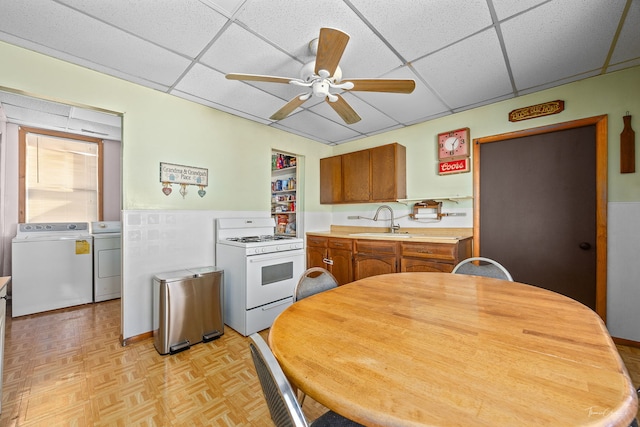 2862 S Keeley St, Chicago, IL 60608 - kitchen with white range with gas stovetop, washer and clothes dryer, a drop ceiling, and a sink