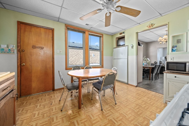 2862 S Keeley St, Chicago, IL 60608 - dining space featuring a drop ceiling, wainscoting, visible vents, and ceiling fan with notable chandelier