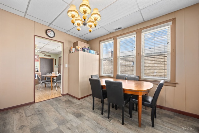 2862 S Keeley St, Chicago, IL 60608 - dining space featuring a drop ceiling, an inviting chandelier, visible vents, and wood finished floors