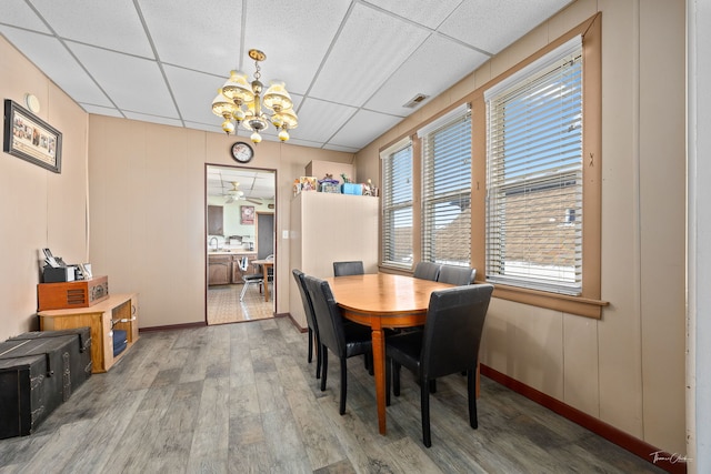 2862 S Keeley St, Chicago, IL 60608 - dining space featuring wood finished floors, a notable chandelier, baseboards, and a drop ceiling