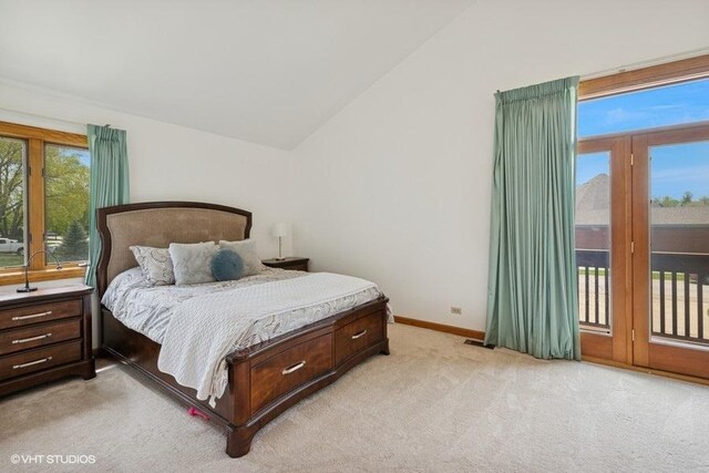 bedroom featuring access to exterior, vaulted ceiling, light colored carpet, and baseboards