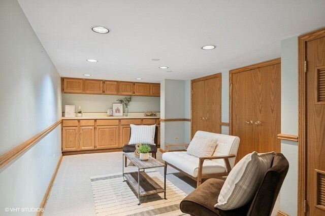 living area with recessed lighting, light colored carpet, and baseboards