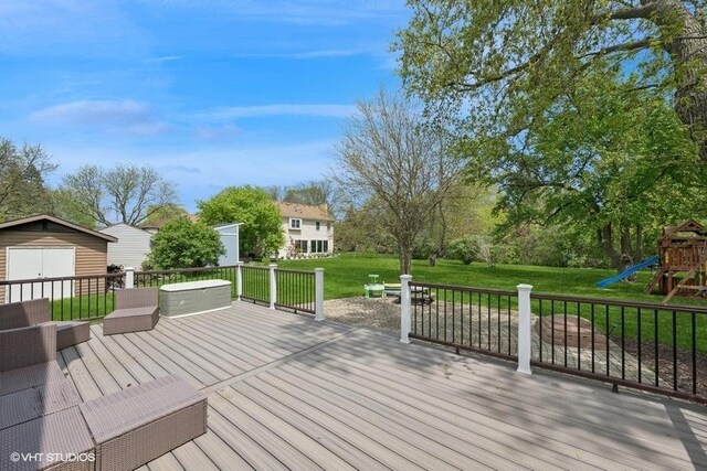 deck featuring a playground, a yard, and an outdoor structure