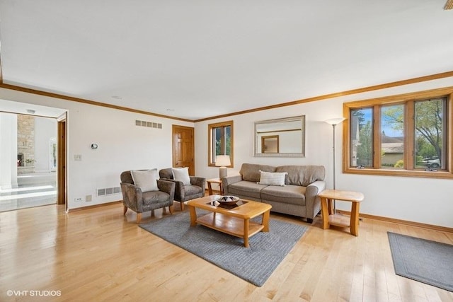 living area featuring baseboards, light wood finished floors, and crown molding