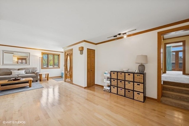 living room featuring ornamental molding, wood finished floors, baseboards, and healthy amount of natural light
