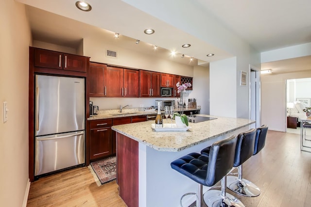 3180 N Lake Shore Dr Unit 4F, Chicago, IL 60657 - kitchen with appliances with stainless steel finishes, a sink, light wood-type flooring, a kitchen bar, and an island with sink
