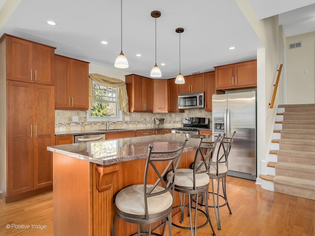 504 S Pierce Ave, Wheaton, IL 60187 - kitchen featuring appliances with stainless steel finishes, a kitchen island, light wood-style flooring, decorative backsplash, and recessed lighting