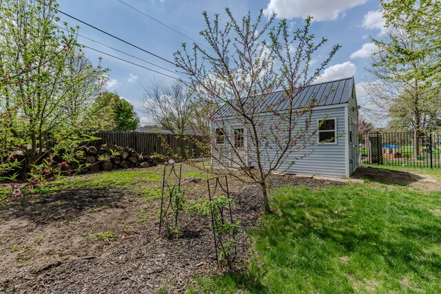 rear view of property with metal roof and an outbuilding